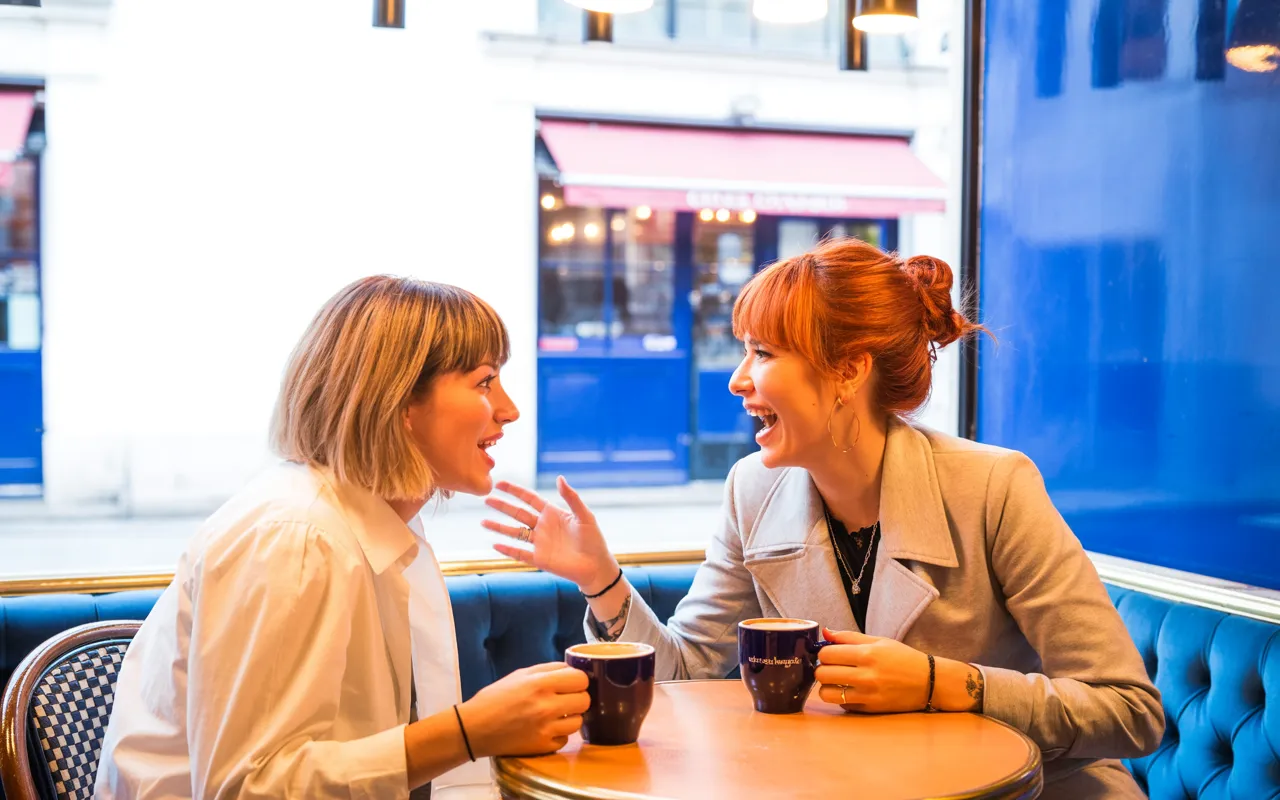 Friends discussing Gardasil vaccine pricing at Covent Garden cafe