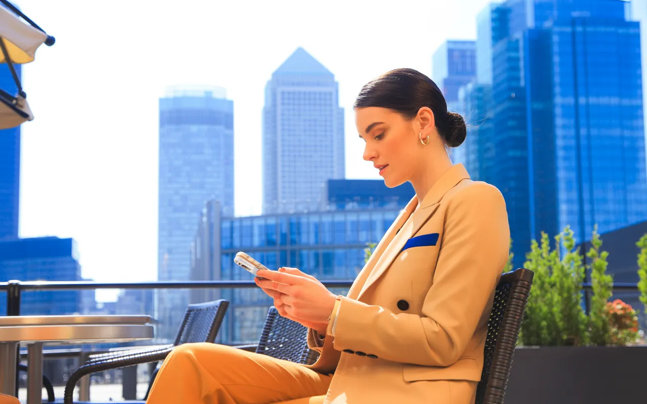 Woman calculating Gardasil vaccine costs at Canary Wharf cafe London